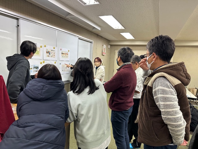 メンバーのみんながマップのデザイン案を確認している様子の写真
