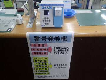 窓口に番号発券機が設置されいる写真