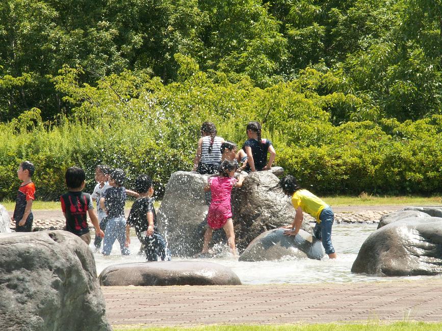 中井中央公園水辺の広場で水しぶきを上げて遊ぶ子どもたちの写真