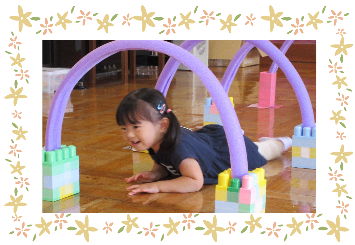 スポンジで作ったアーチを腹ばいでくぐる女の子