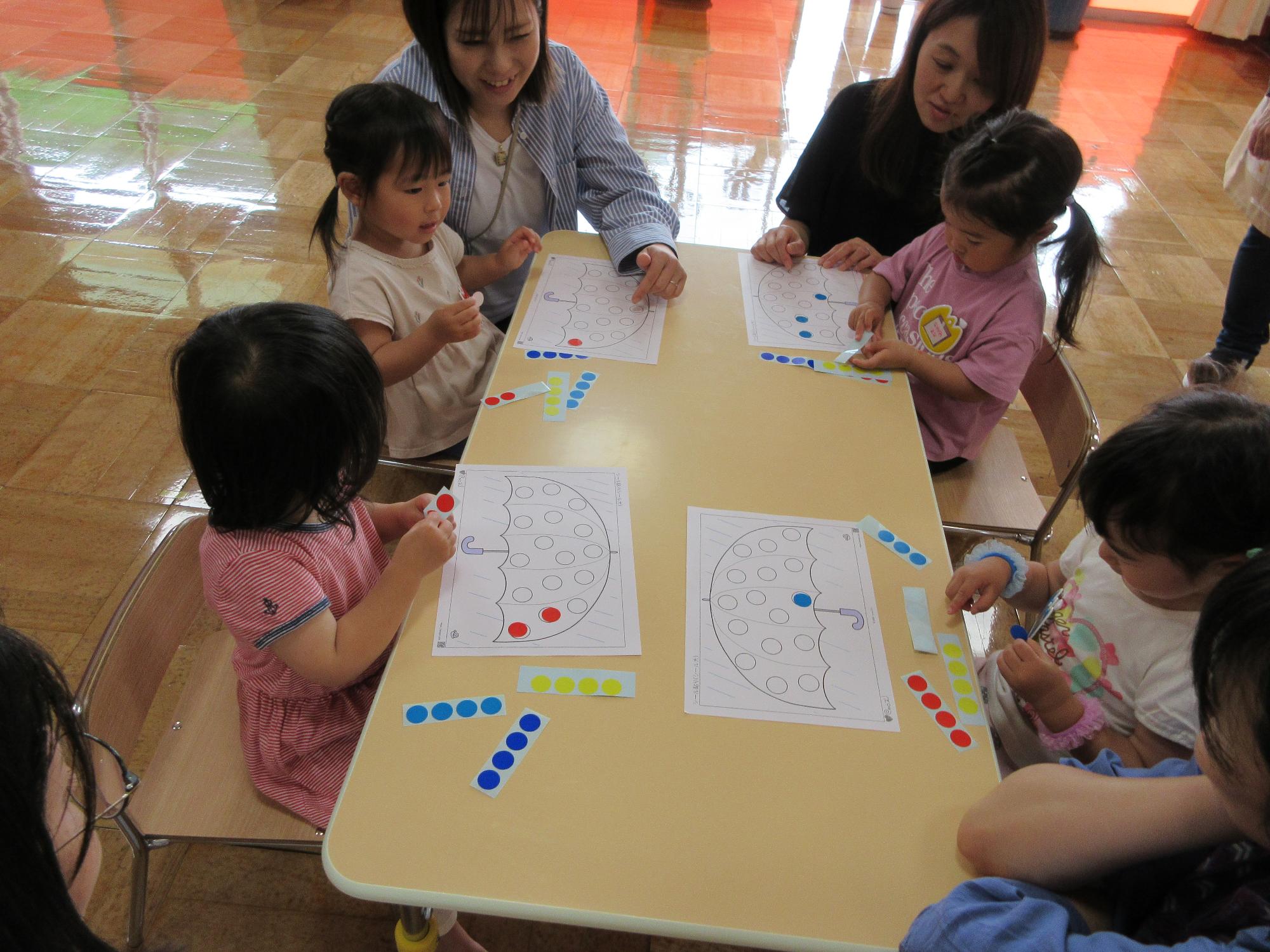なかよしクラブに参加した親子がシール貼りをしている様子
