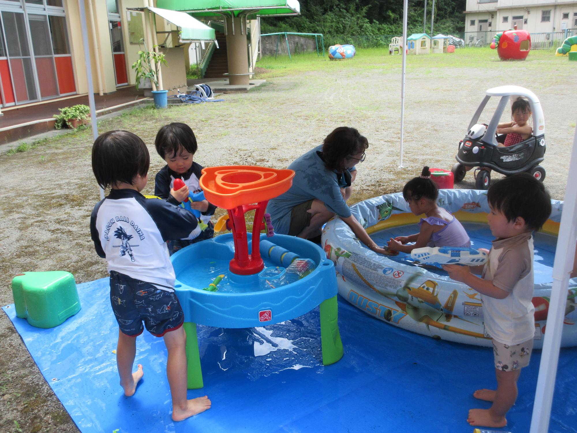 4人の児童が水遊びをしている様子