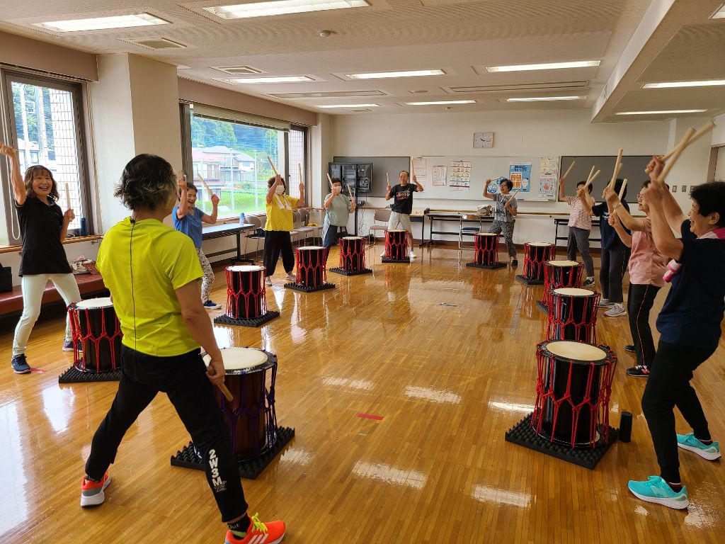 太鼓のばちを天井に向け、振り上げ振り下ろしをしているところ