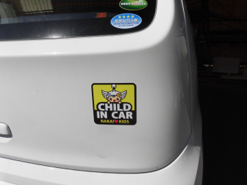 自動車の後ろに「なかまる」がデザインされたオリジナルの「CHILD IN CAR マグネット」が貼ってある写真