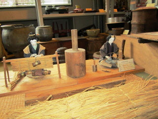 藁を使った手作業での加工の様子を人形で再現している写真