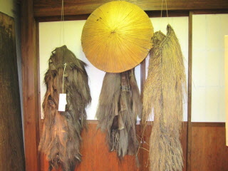 傘や棕櫚蓑（しゅろみの） が展示されている写真