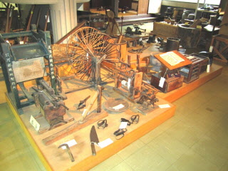 踏み車や鎌、農作業に使う機械など色々な種類の昔の道具が展示されている写真