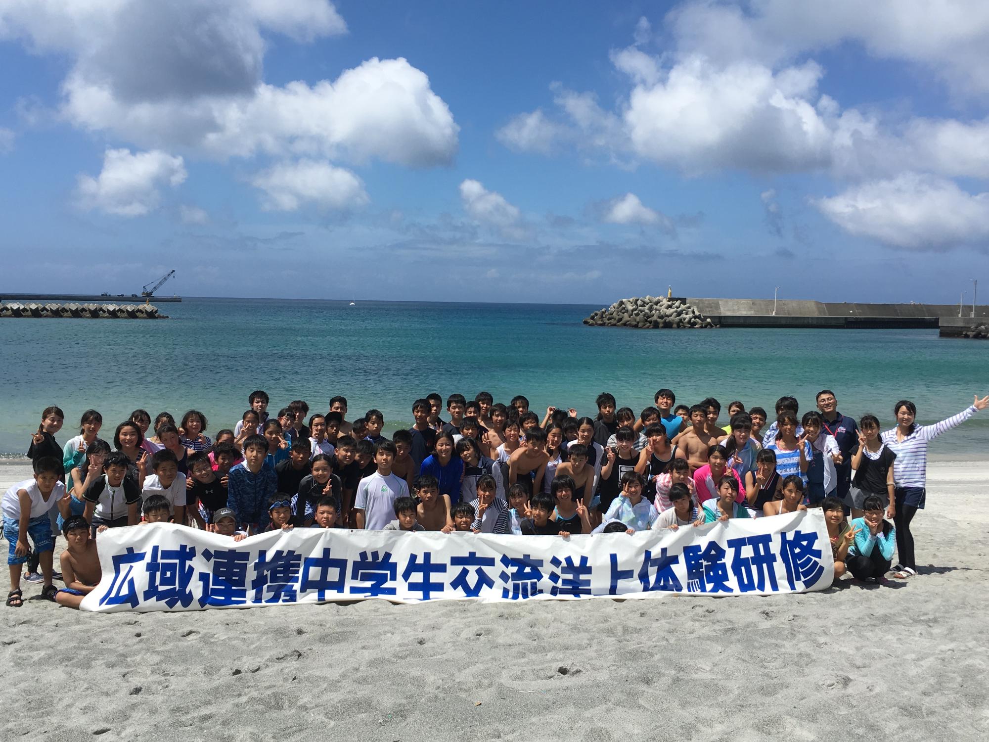 洋上体験の参加者が砂浜で集合写真
