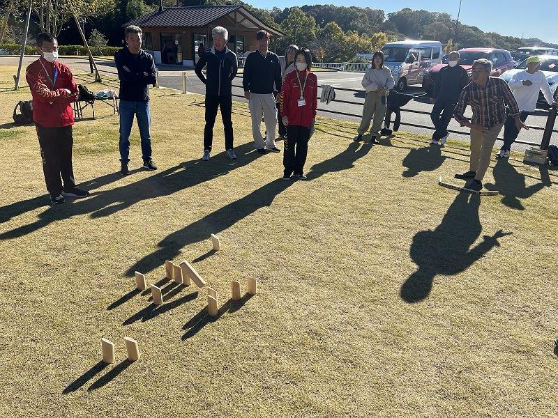 10名ほどで芝生の上でモルックを体験している写真