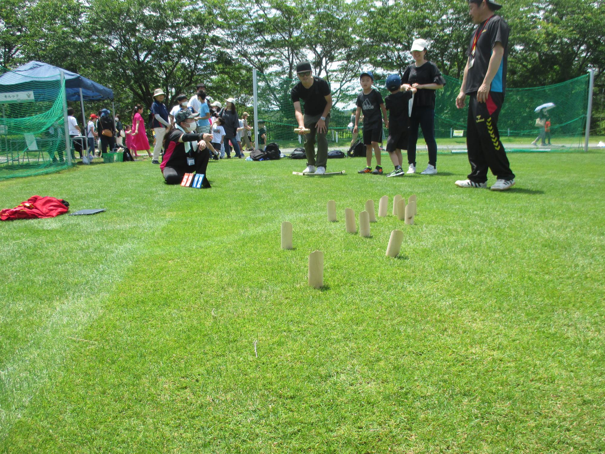 芝生の上で数名がモルックで遊んでいる写真